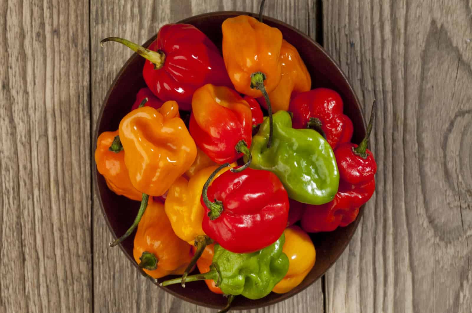 bowl of habanero chili peppers on wooden table