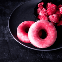 raspberry donuts on a black plate