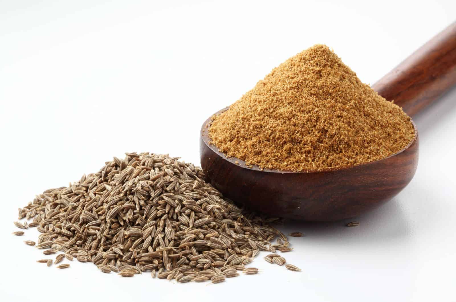 graines de cumin et poudre de cumin dans une cuillère