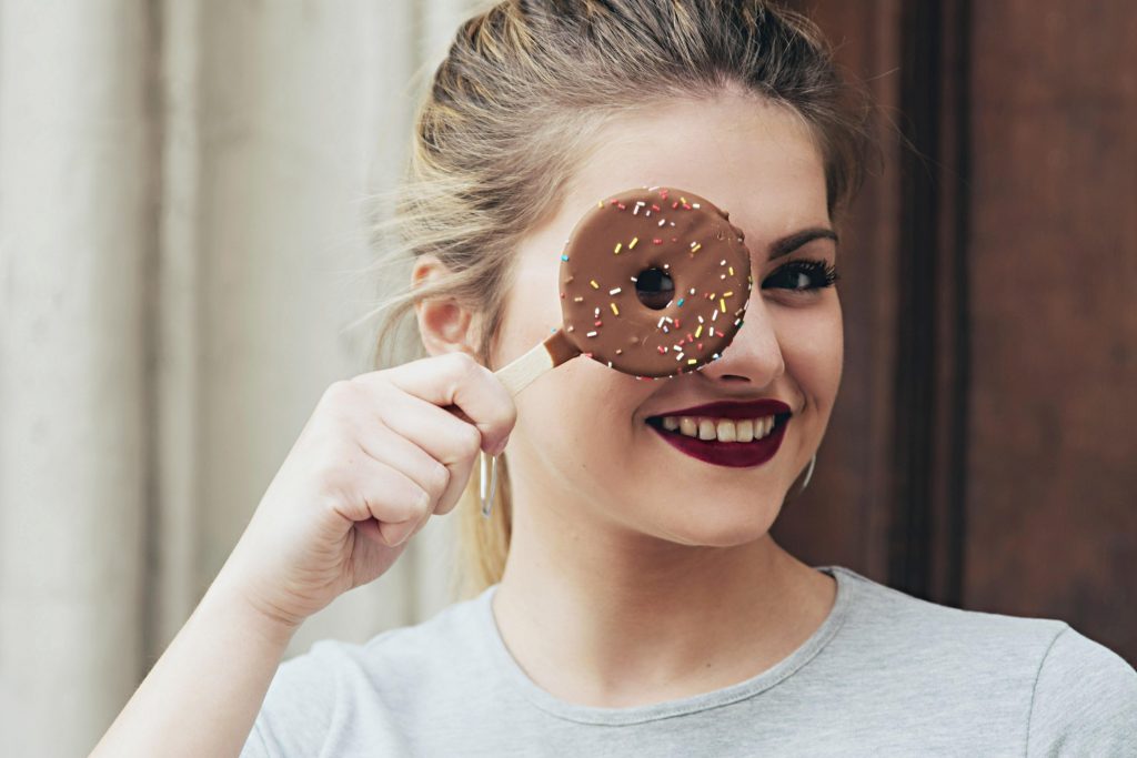 girl holding a frozen donut