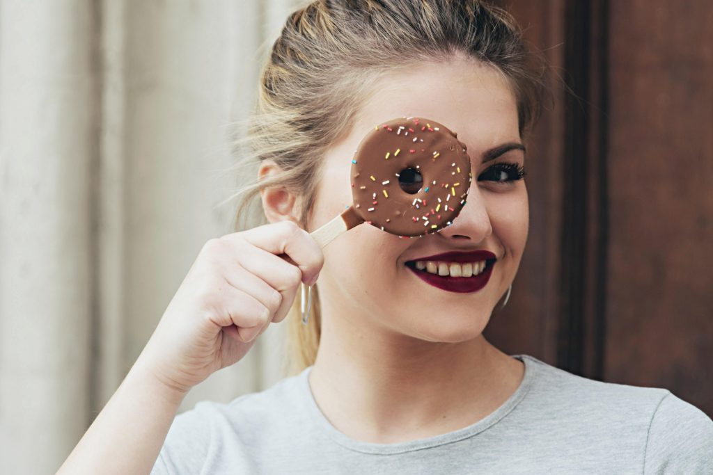 ragazza con in mano una ciambella surgelata