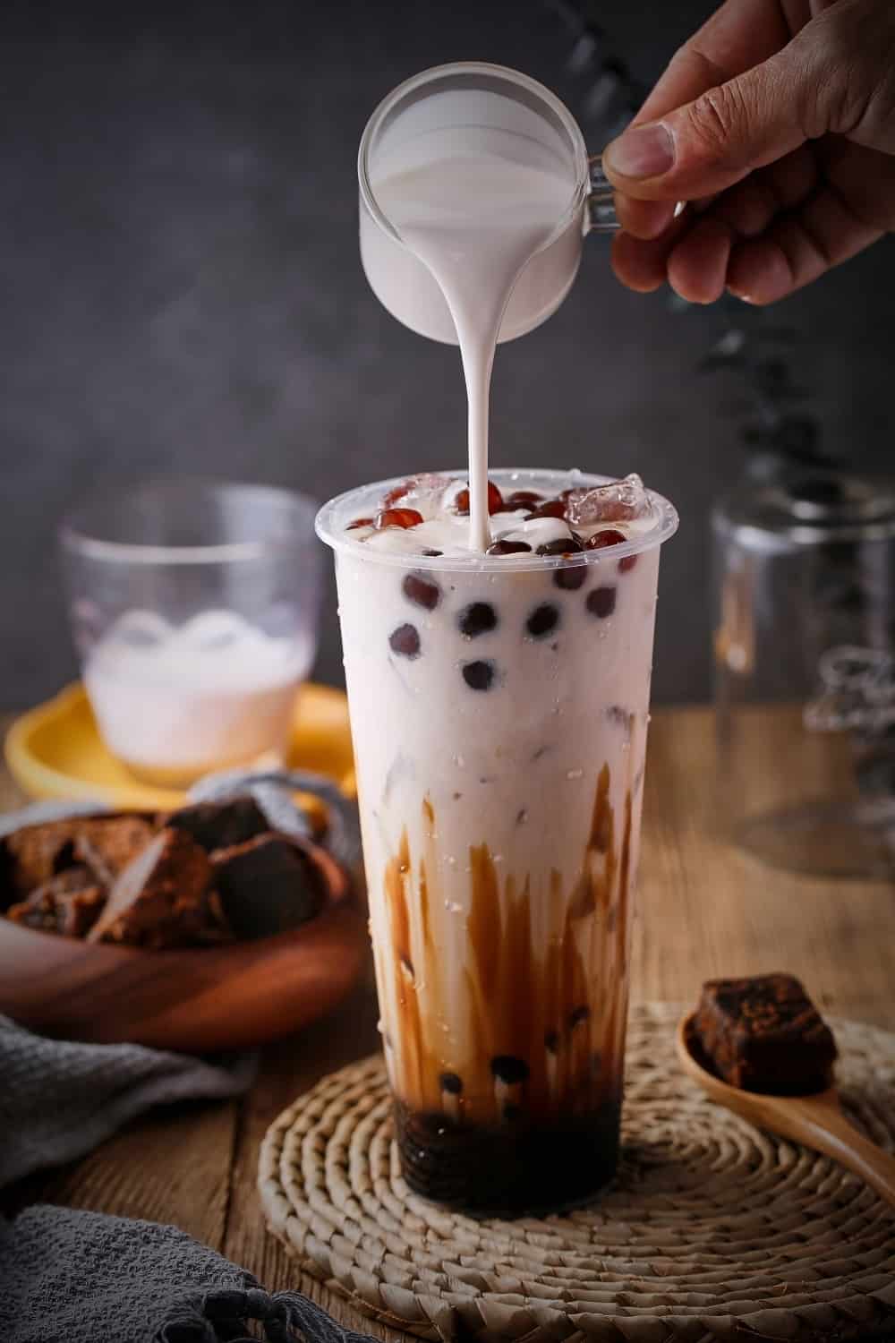 Fotografía publicitaria de té negro con leche y burbujas