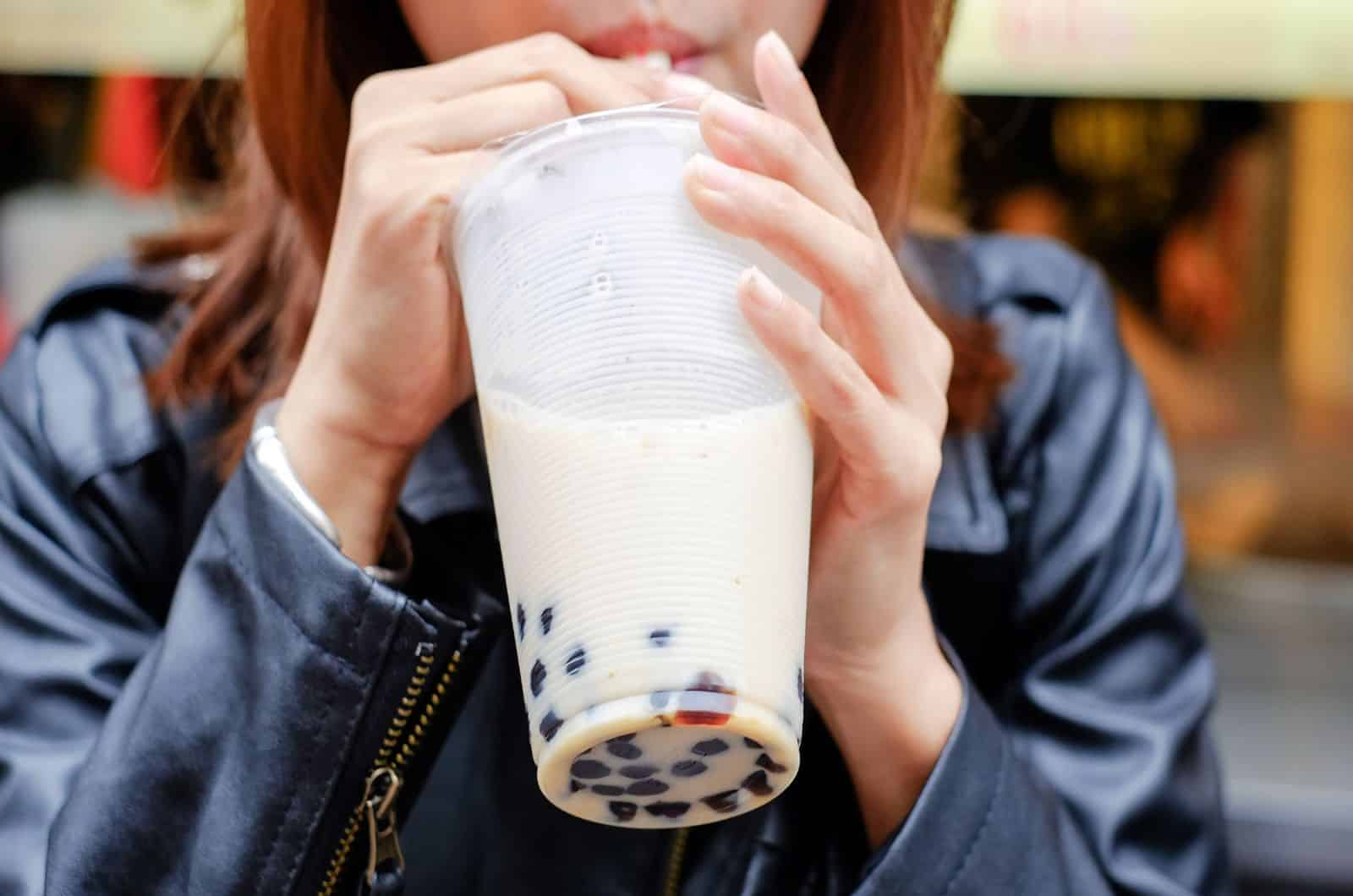 Women drink pearl milk tea through a straws