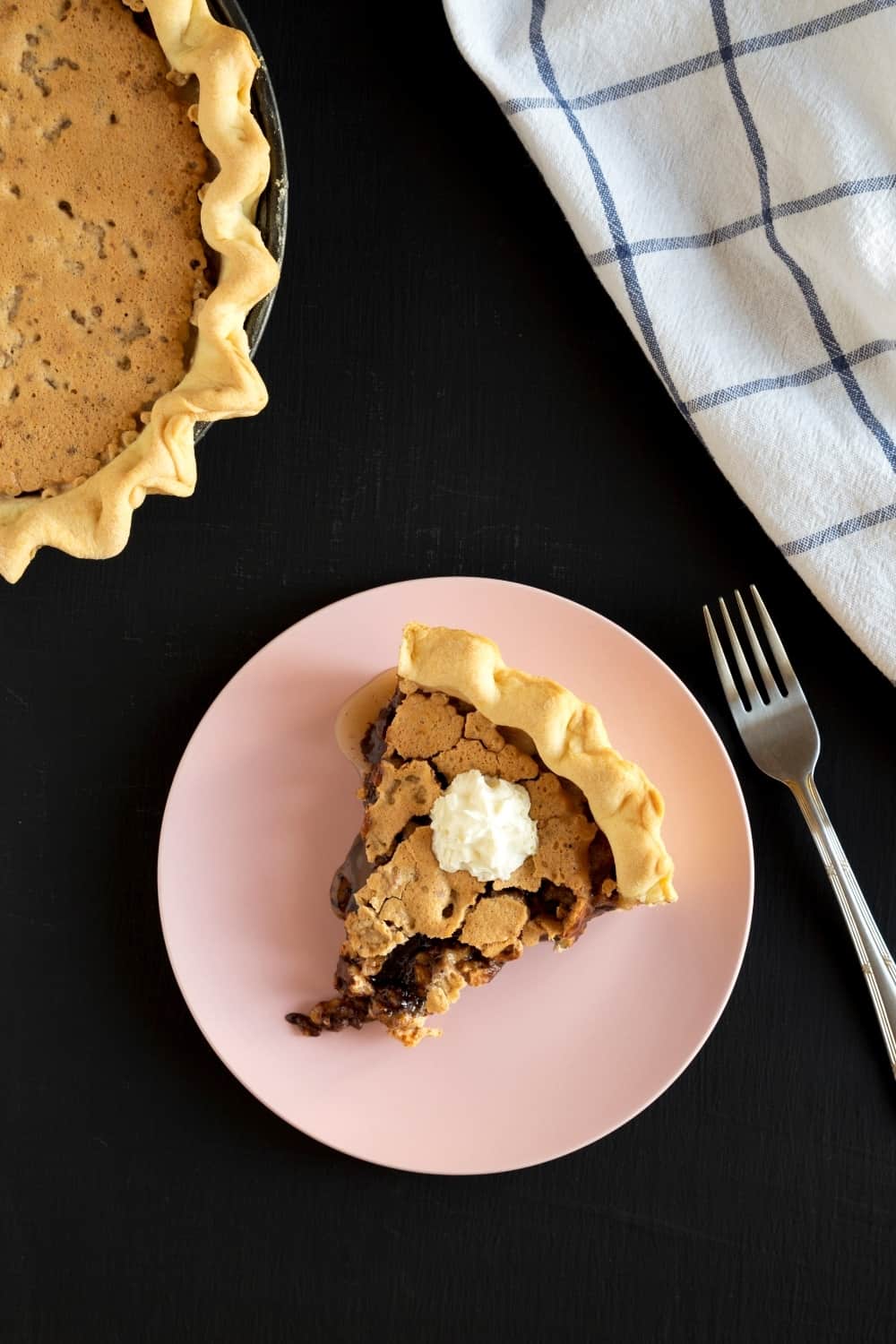 A piece of homemade Chocolate Walnut Derby Pie on a pink plate