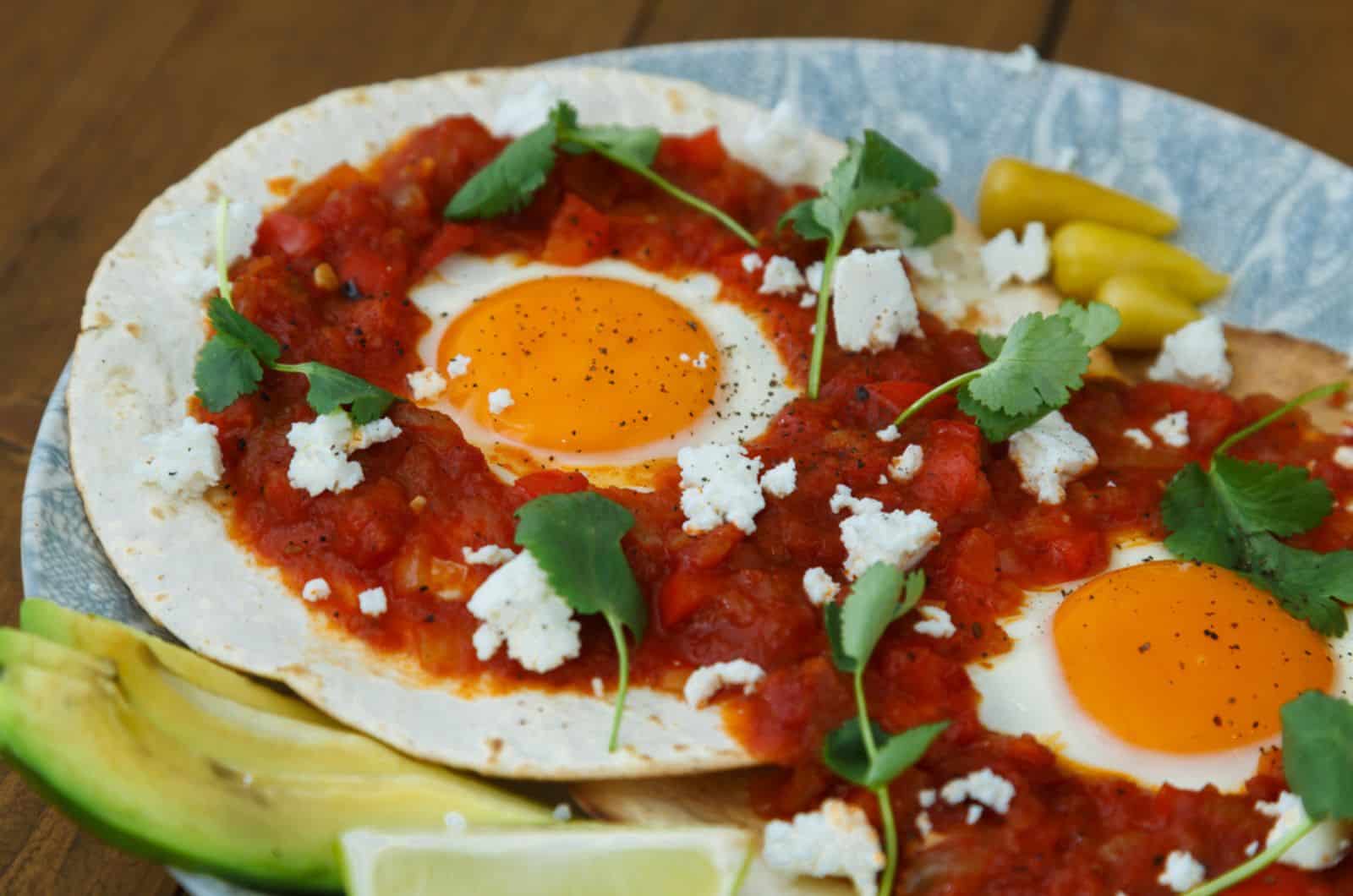 Desayuno con huevo frito y salsa sobre tortilla de harina a la plancha