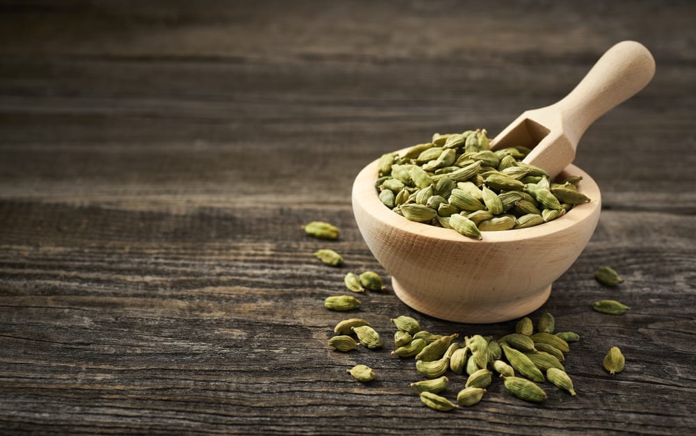 Cardamom in a wooden scoop