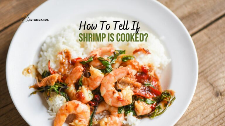 shrimp and rice in a white plate on wooden table