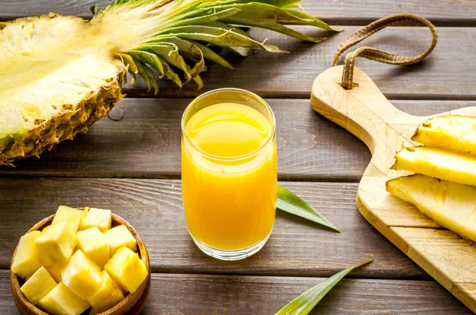 Pineapple Juice and Pineapple  sitting on table 