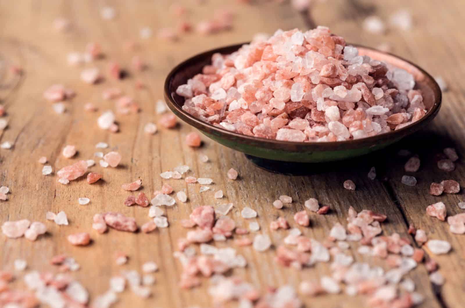Pink salt from the Himalayas in a bowl on wooden table