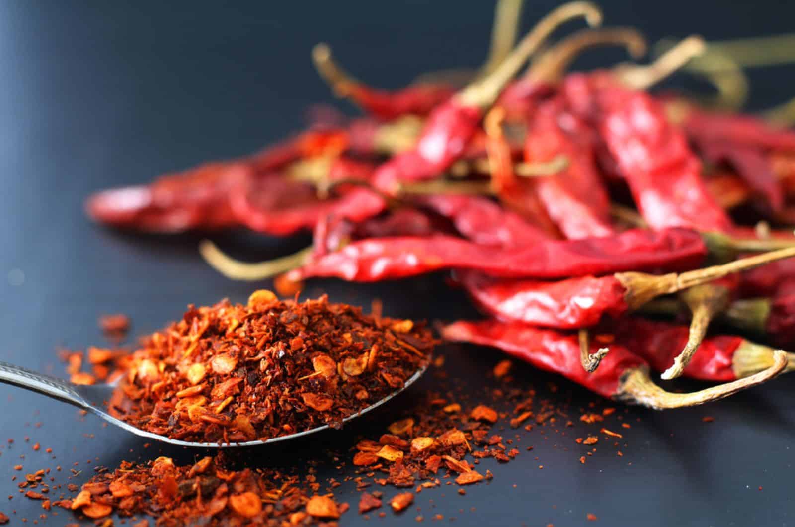  poivre de Cayenne sur une cuillère en métal et piment rouge séché