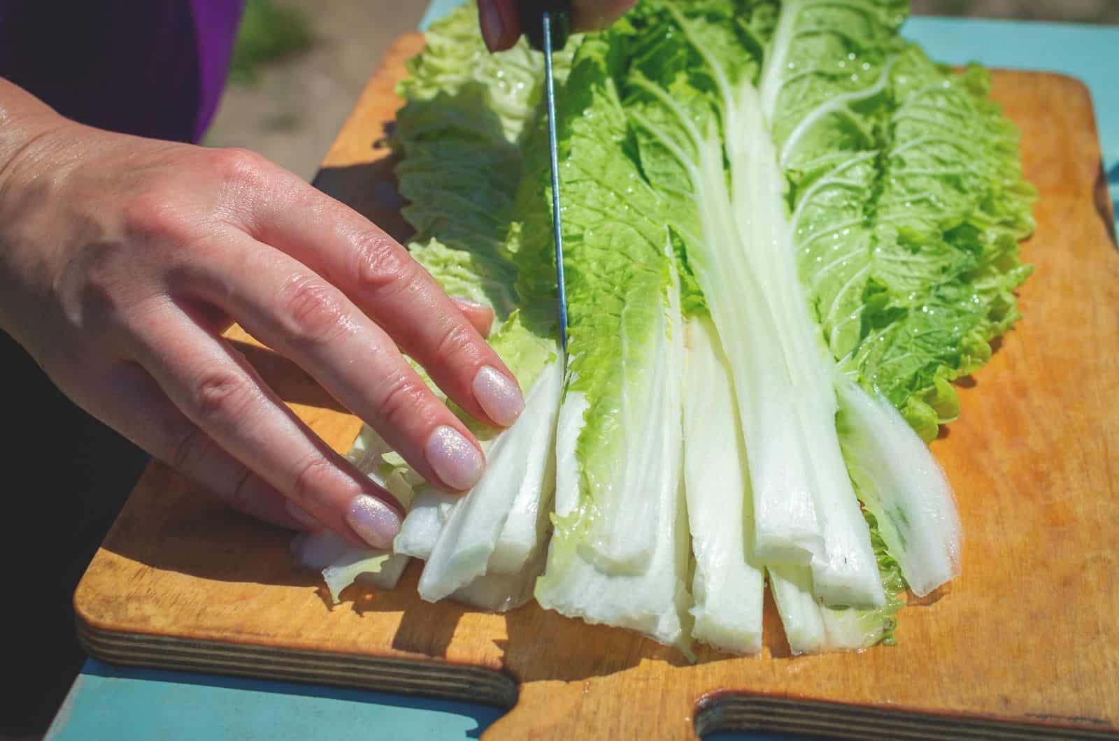 man cutting lettuce