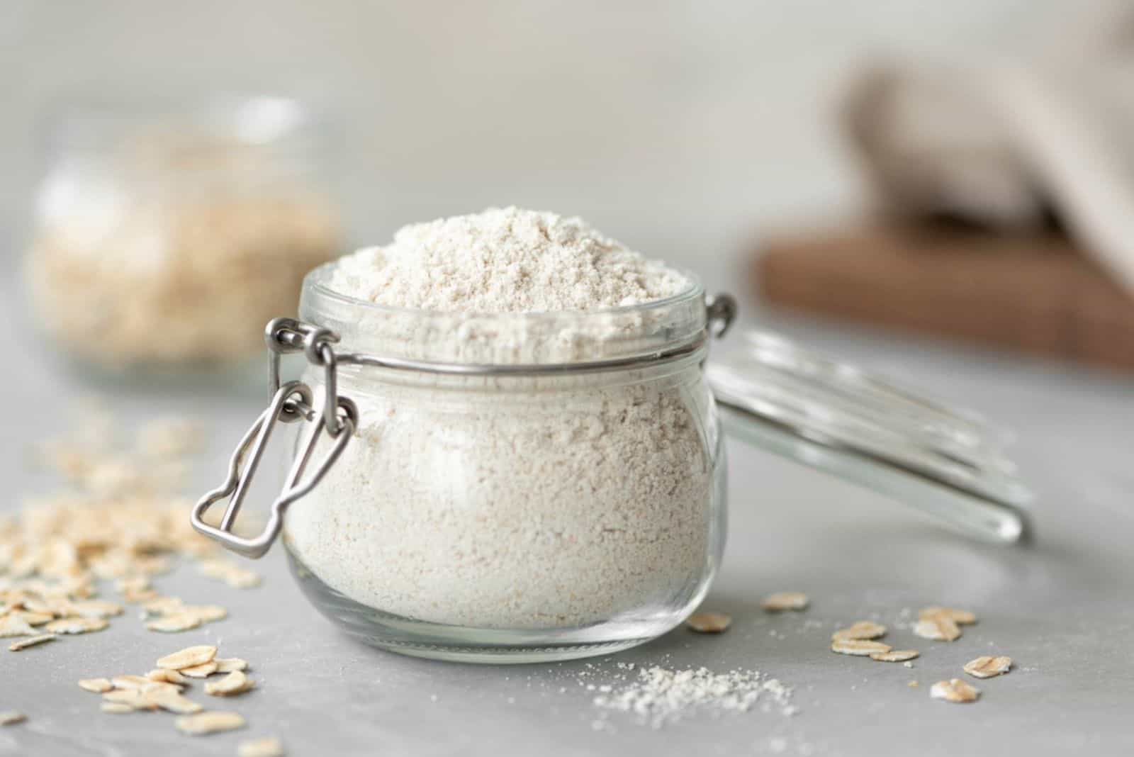 harina de avena en un tarro de cristal sobre una mesa blanca