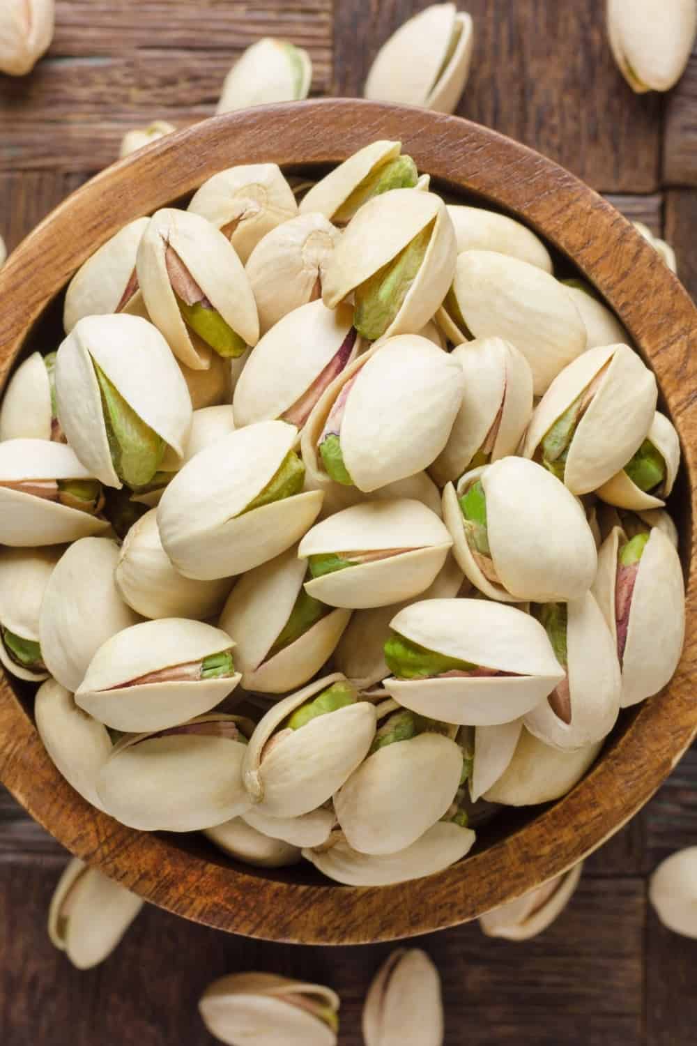 pistachio in shell nuts in bowl on wooden table