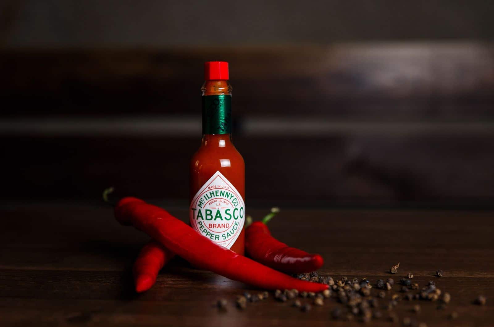 tabasco sauce bottle with red chilli and black peppers