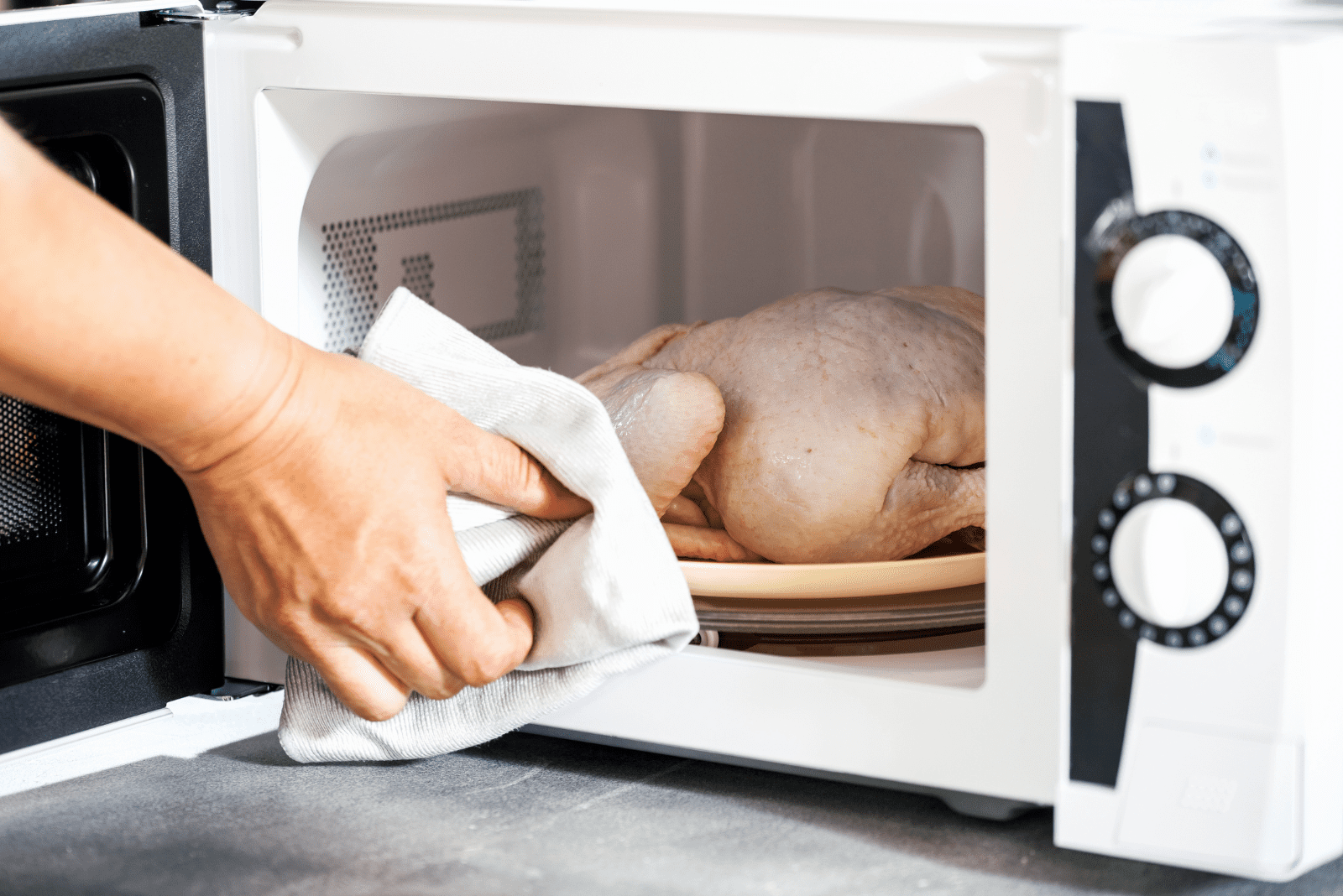 la femme sort le poulet décongelé du micro-ondes