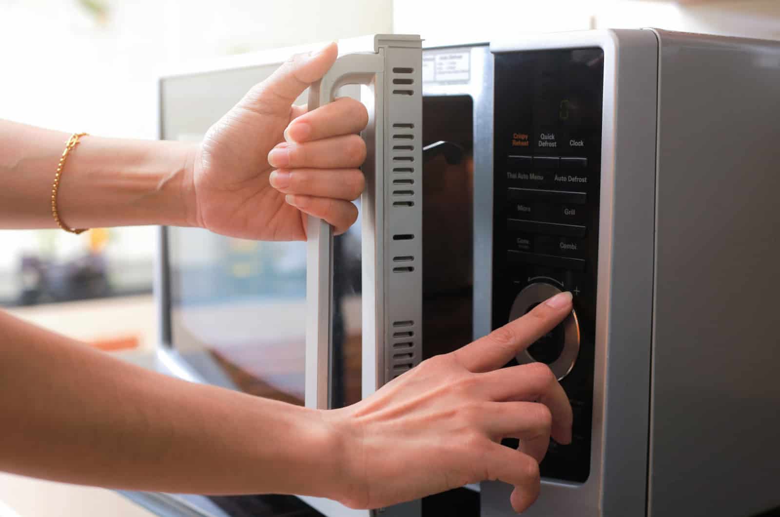 woman closing microwave door