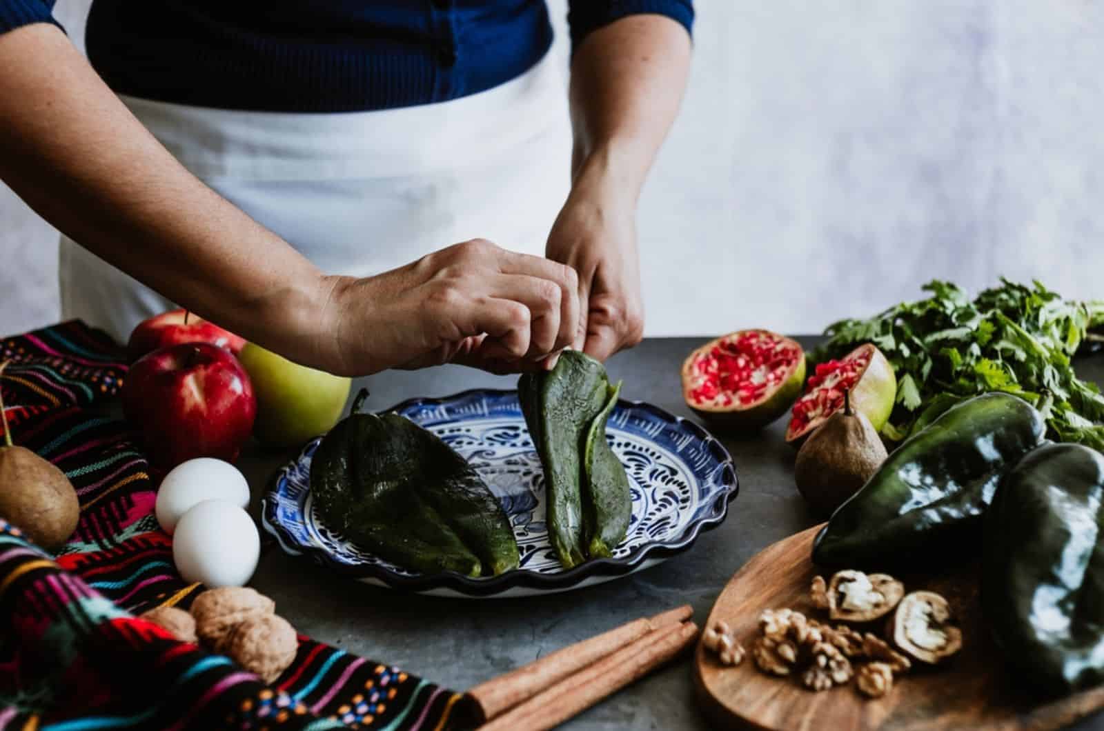 woman hands peeling poblano chillies pepper for cooking