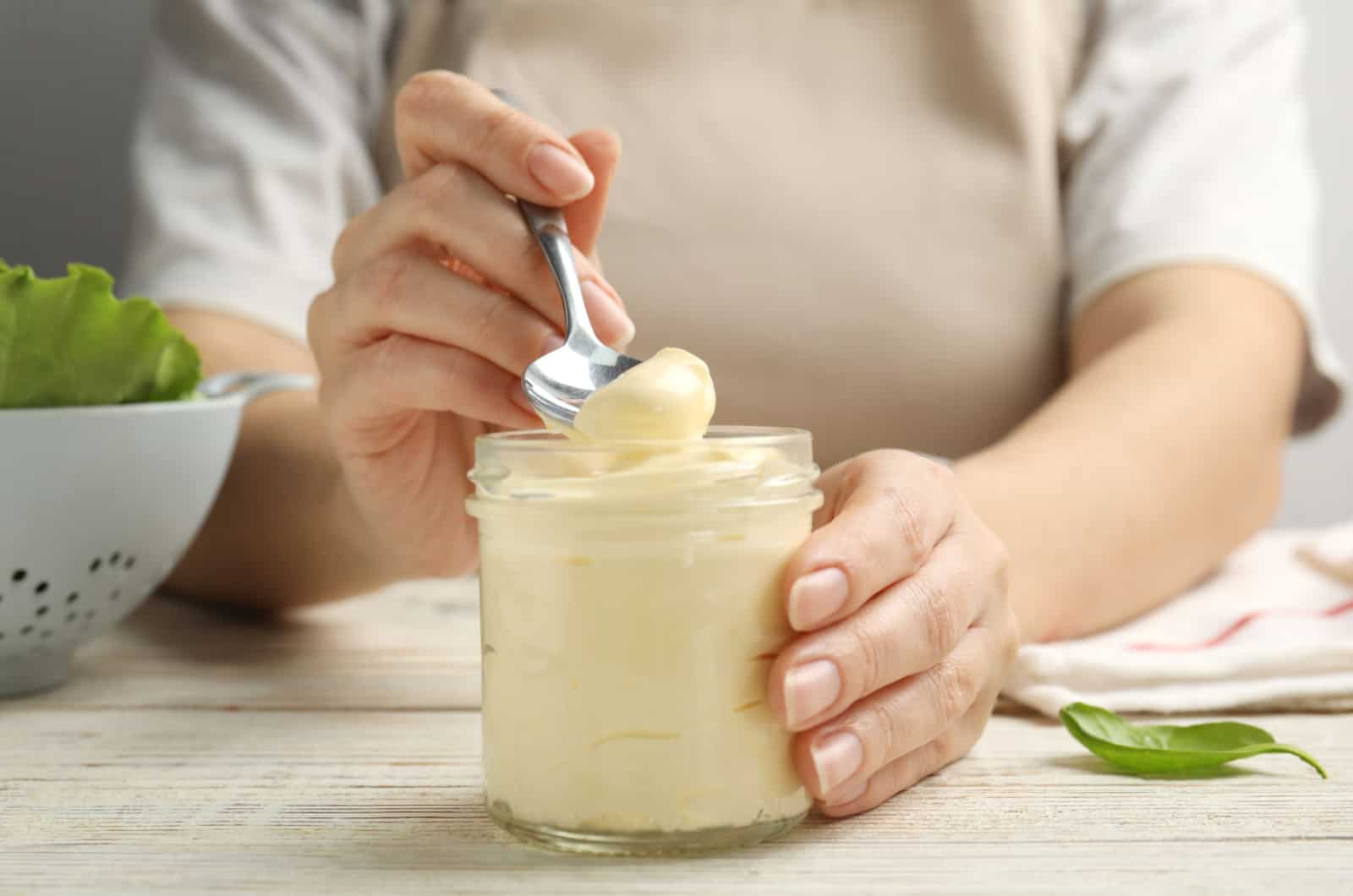 Frau hält ein Glas Mayo