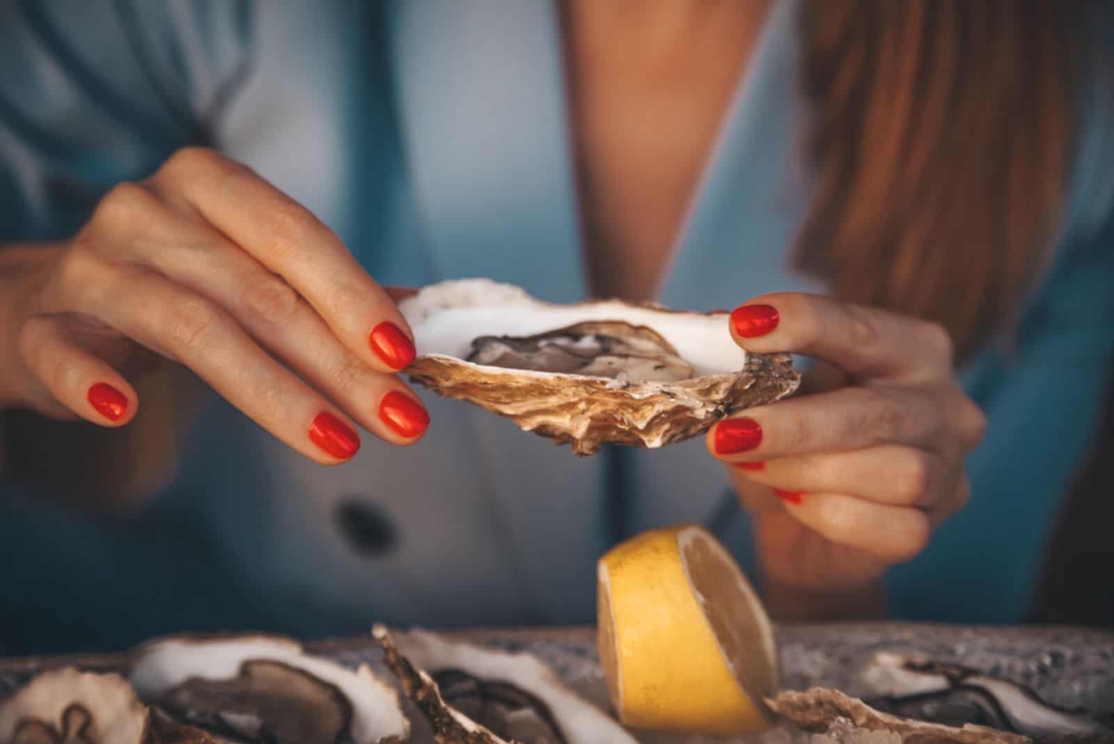 giovane ragazza con ostriche in mano