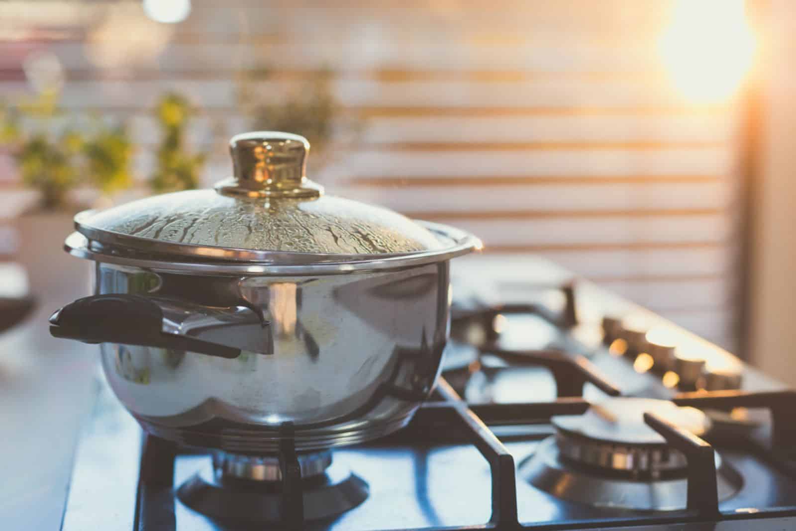 Boiling water in the pot on the stove in the evening