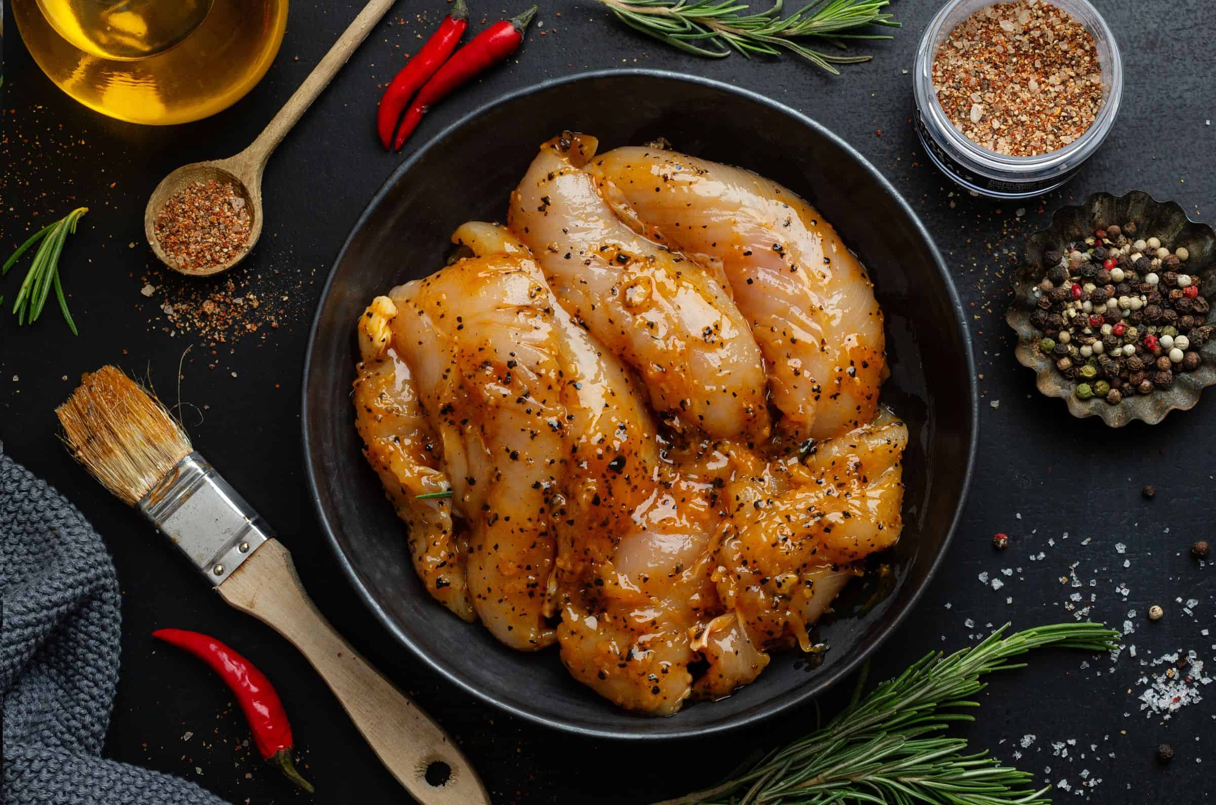 Marinated Chicken in bowl and spices on table