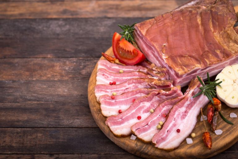 Homemade smoked bacon on wooden board