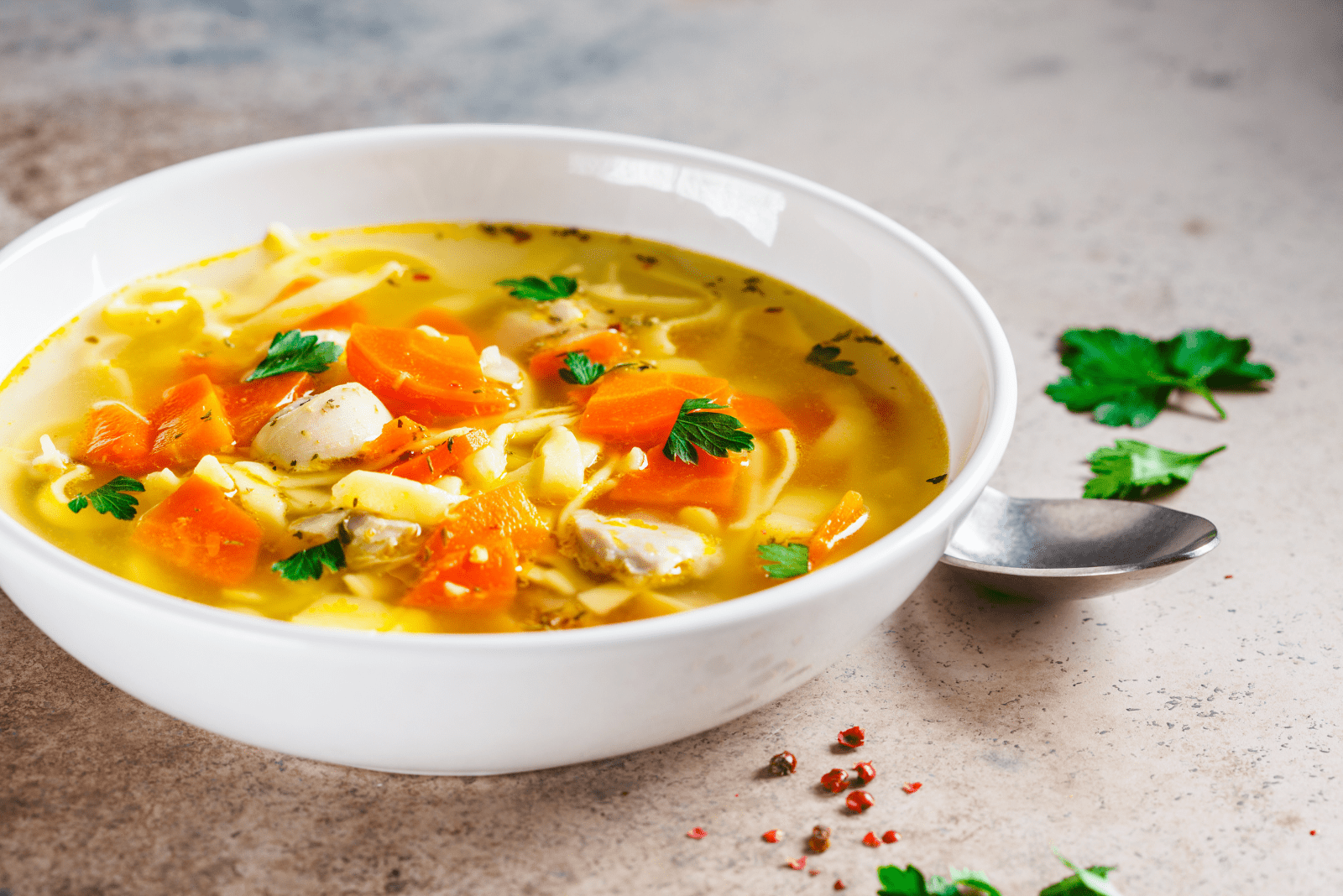 Soupe poulet-nouilles dans une assiette blanche