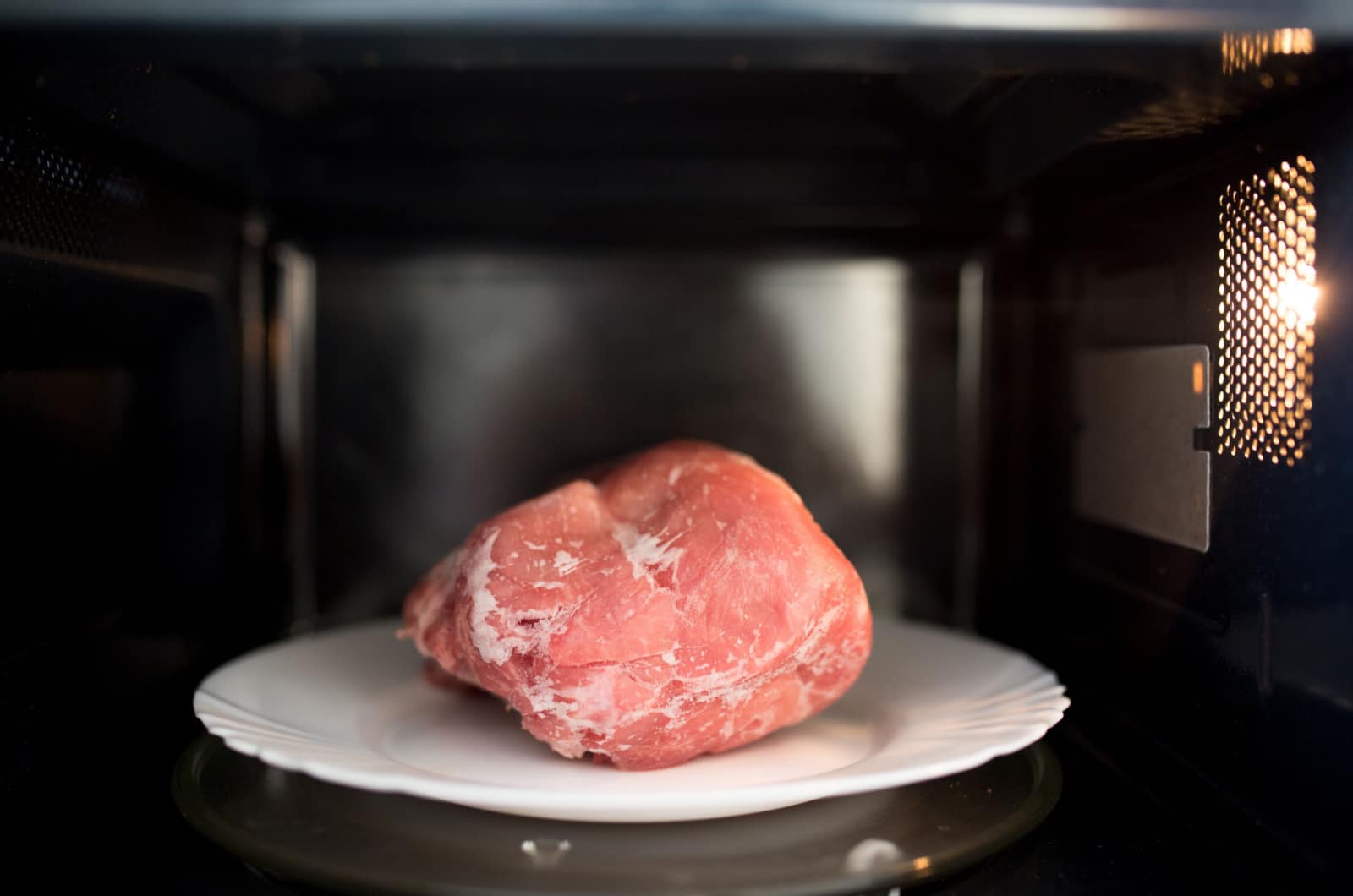 Gefrorenes Schweinefleisch, aufgetaut in der Mikrowelle