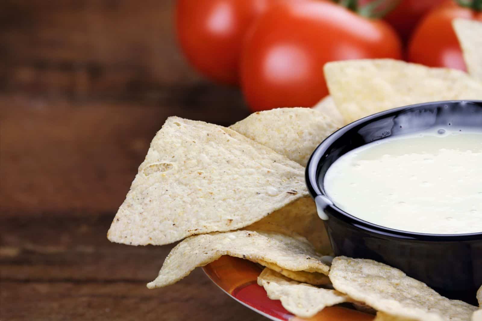 Queso Blanco or White Cheese Sauce with corn tortilla chips and fresh tomatoes
