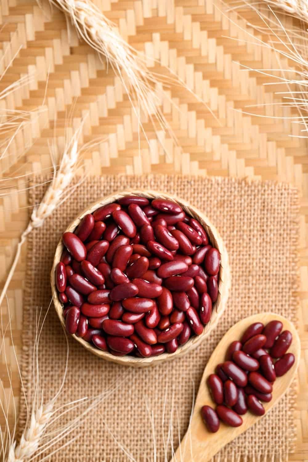 Semillas de alubias rojas en cesta de bambú con cuchara, ingredientes alimentarios