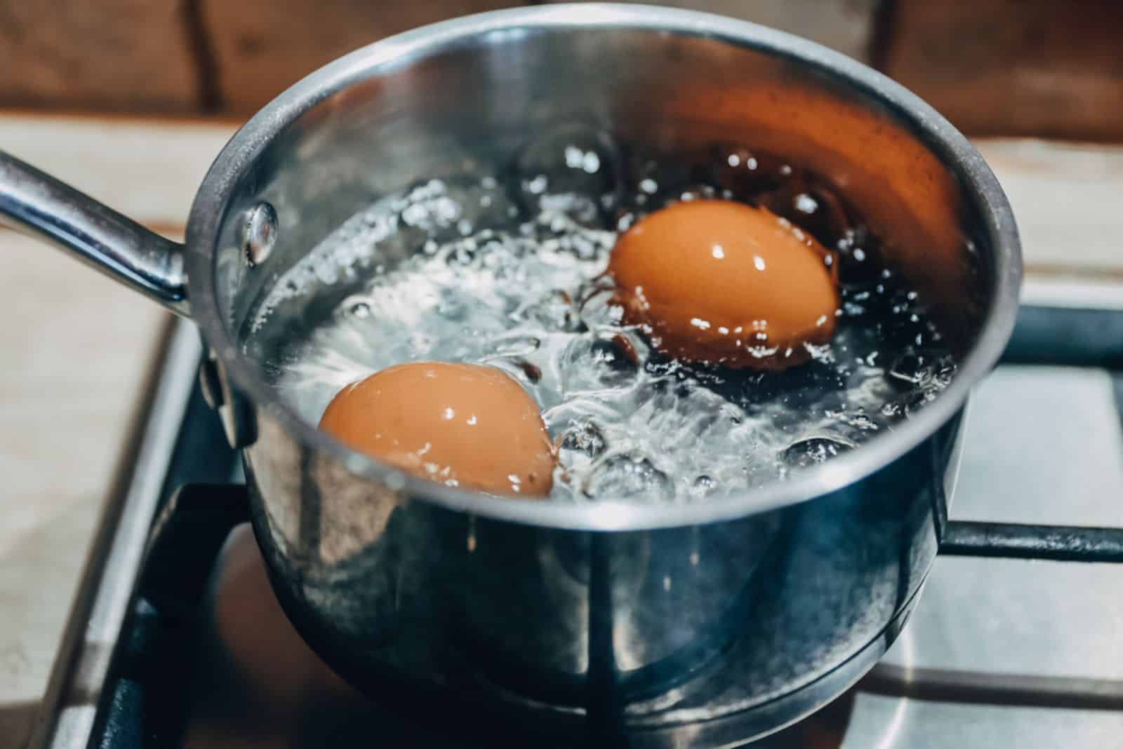 Kochtopf mit kochenden Eiern auf einem Gasherd