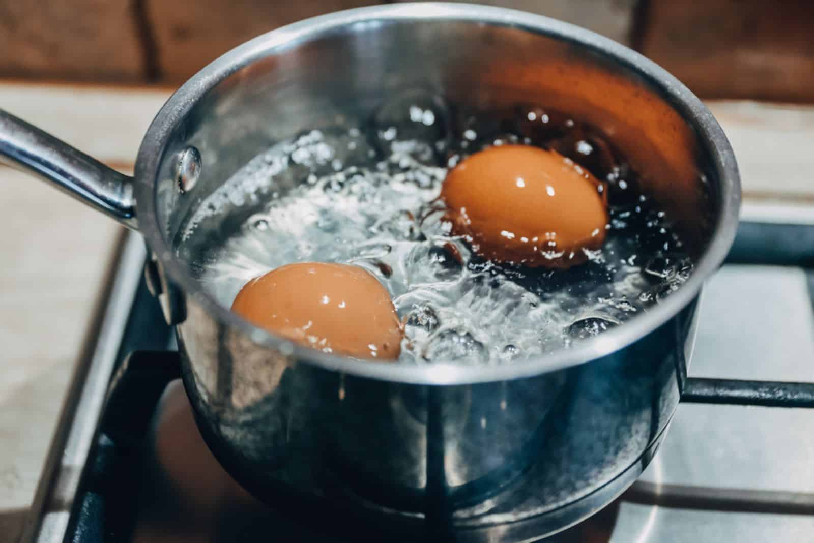 Pentola con uova bollenti su un fornello a gas