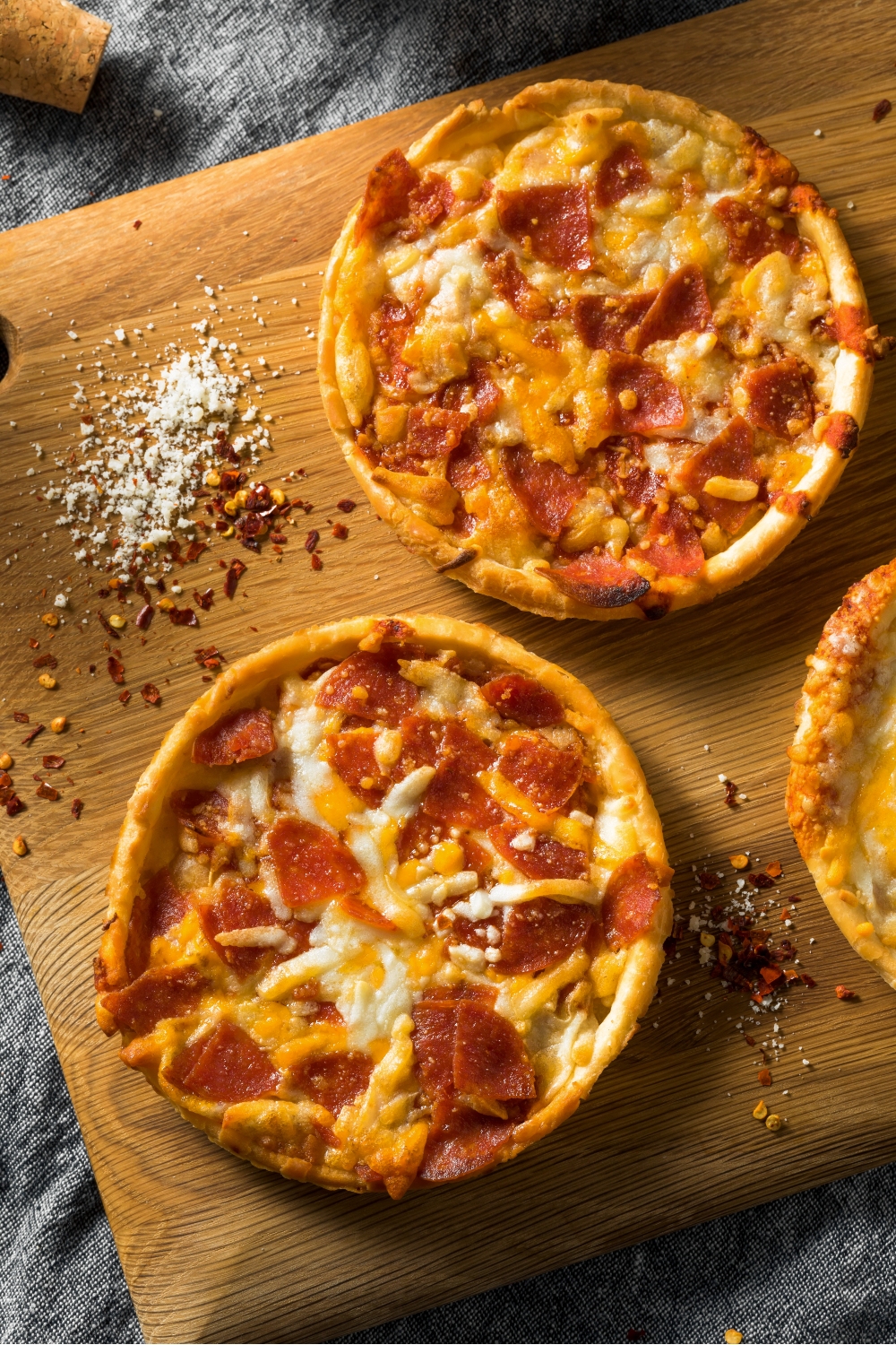 frozen pizza on wooden cutting board