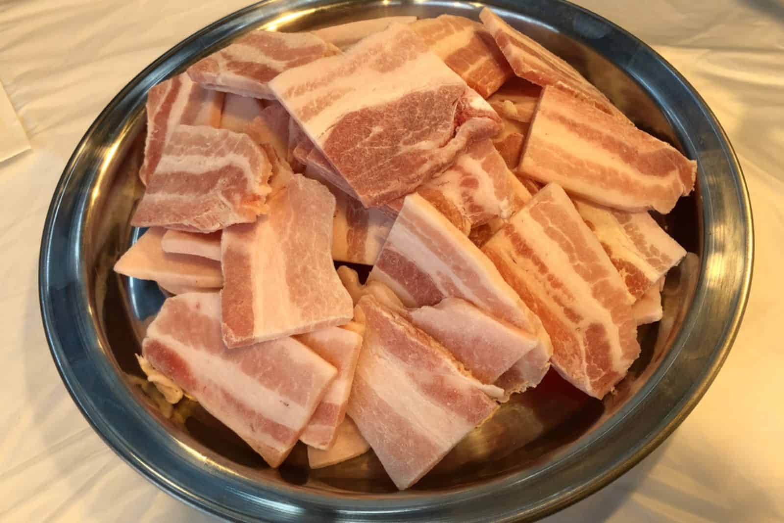 frozen uncooked bacon in a bowl