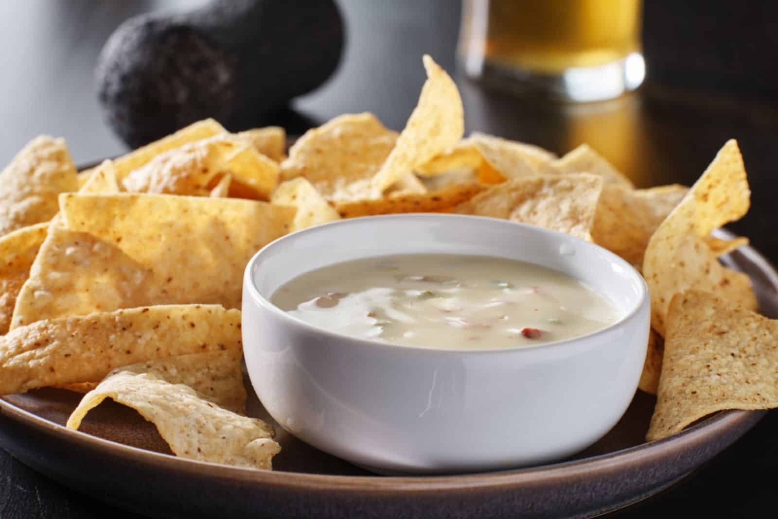 molho de queijo quente mexicano queso blanco com tortilhas de milho no prato