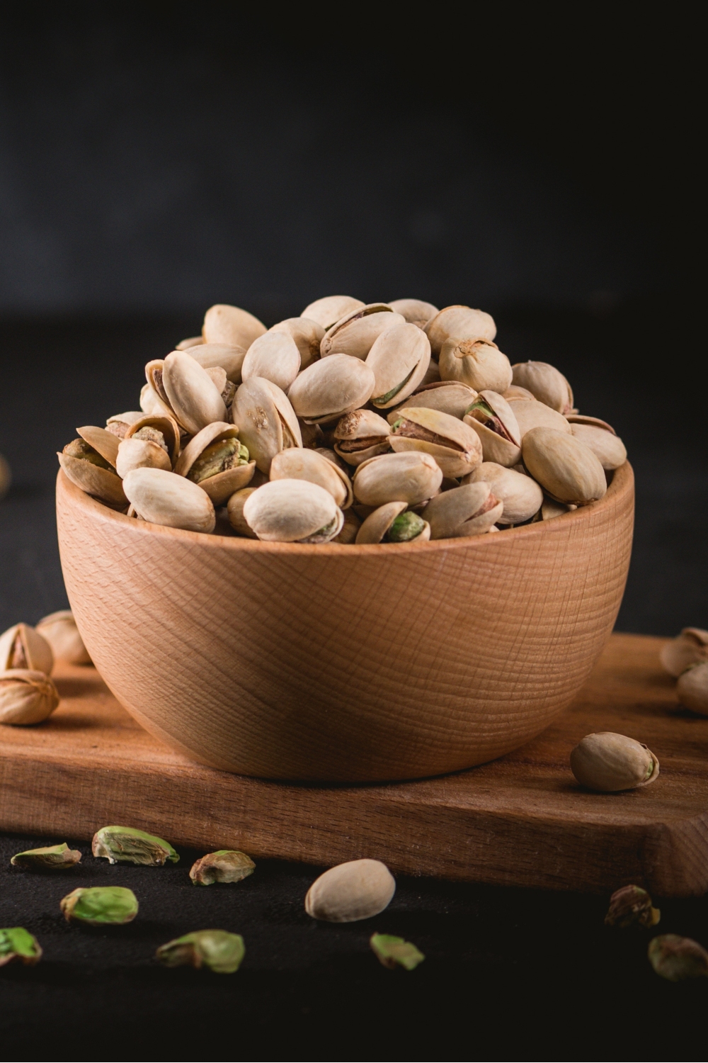 pistachios in a bowl on a black background