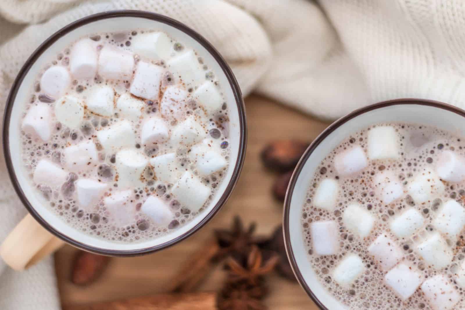 duas canecas com chocolate quente e marshmallow derretido