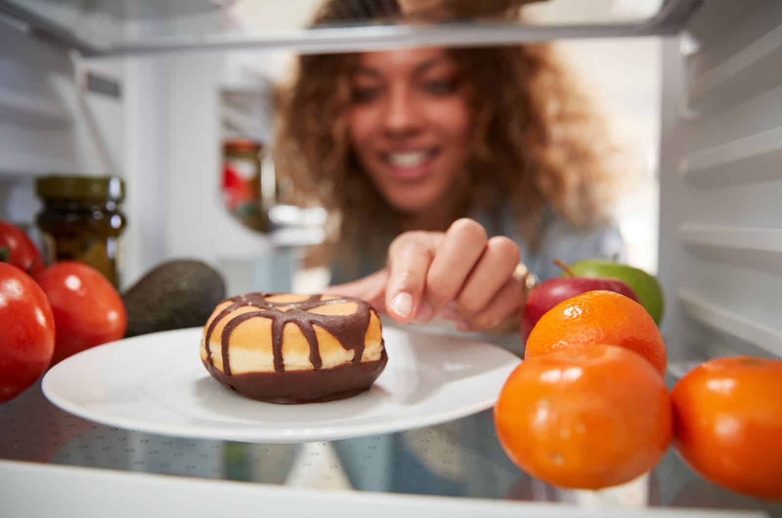 woman taking Donut from fridge