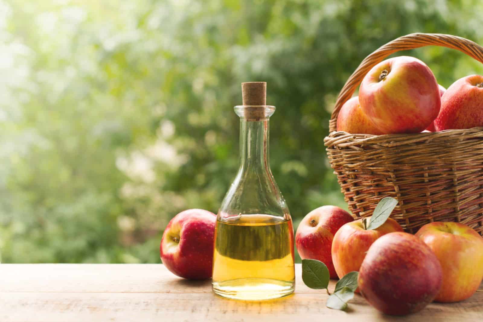 Vinaigre de cidre de pomme en bouteille avec des pommes