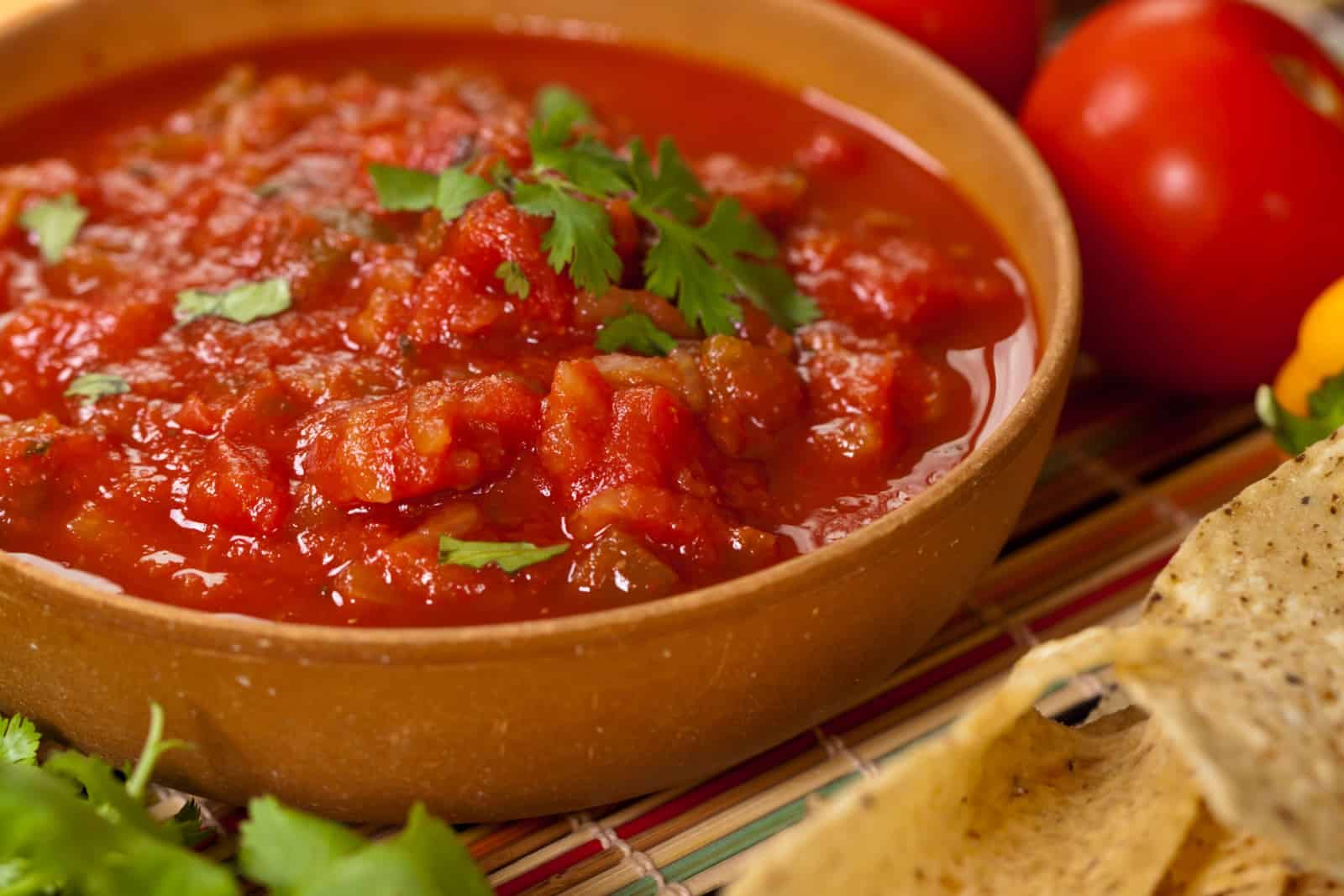 Tazón de salsa roja con tortilla chips, cocina mexicana