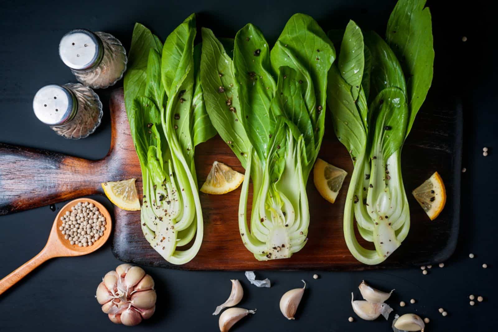 Fresh Chinese cabbage or Bok Choy with lemon slice and pepper on blue dish
