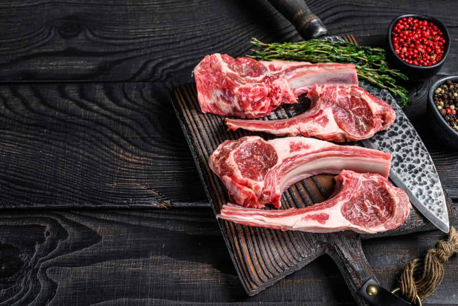 Lamb chops raw meat on bone with salt, pepper and herbs