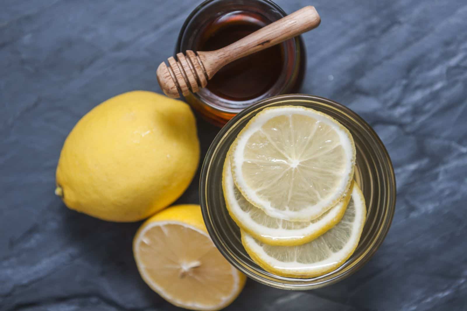 Limonada con limón fresco y miel sobre fondo negro de piedra