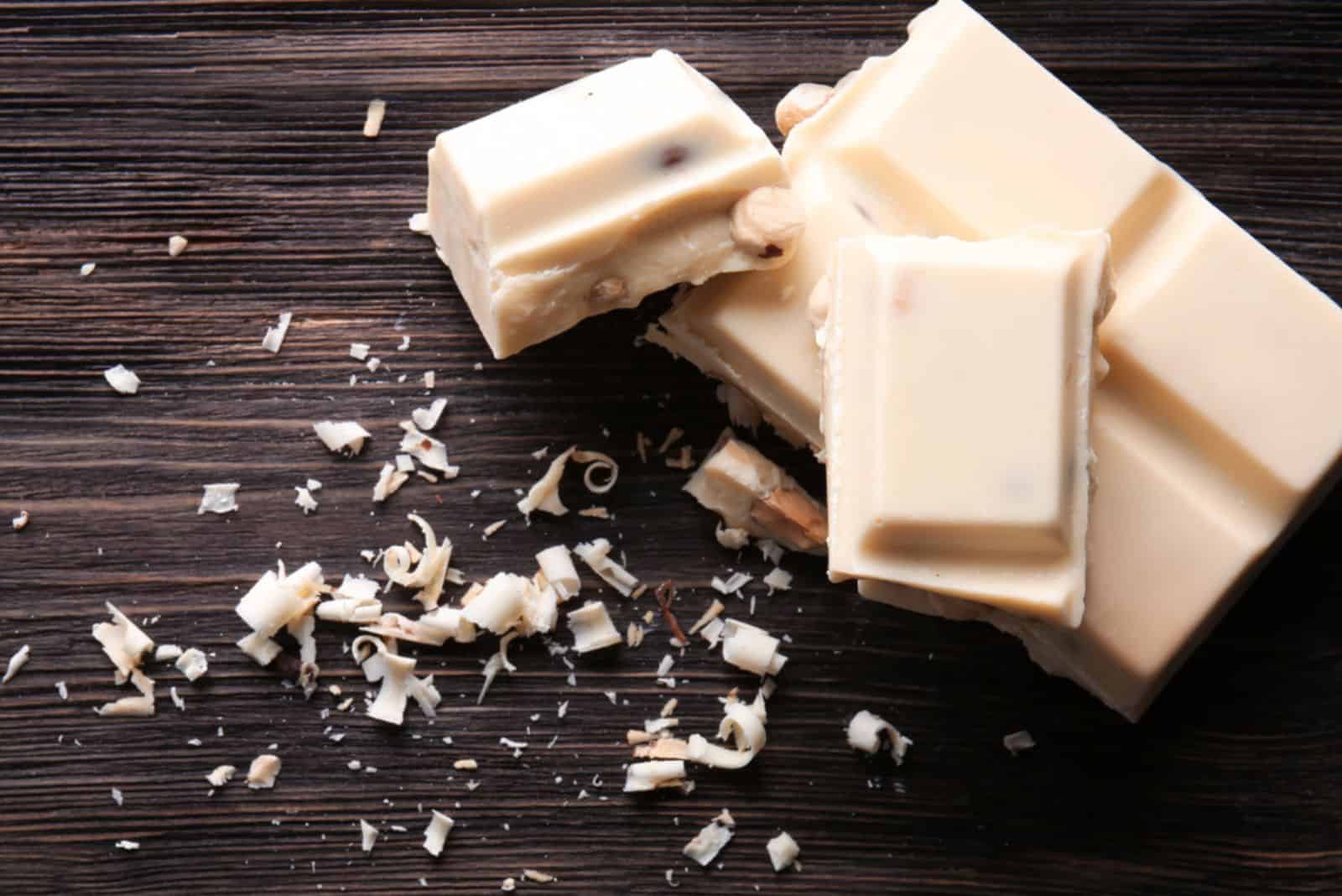 Pieces of white chocolate on wooden table
