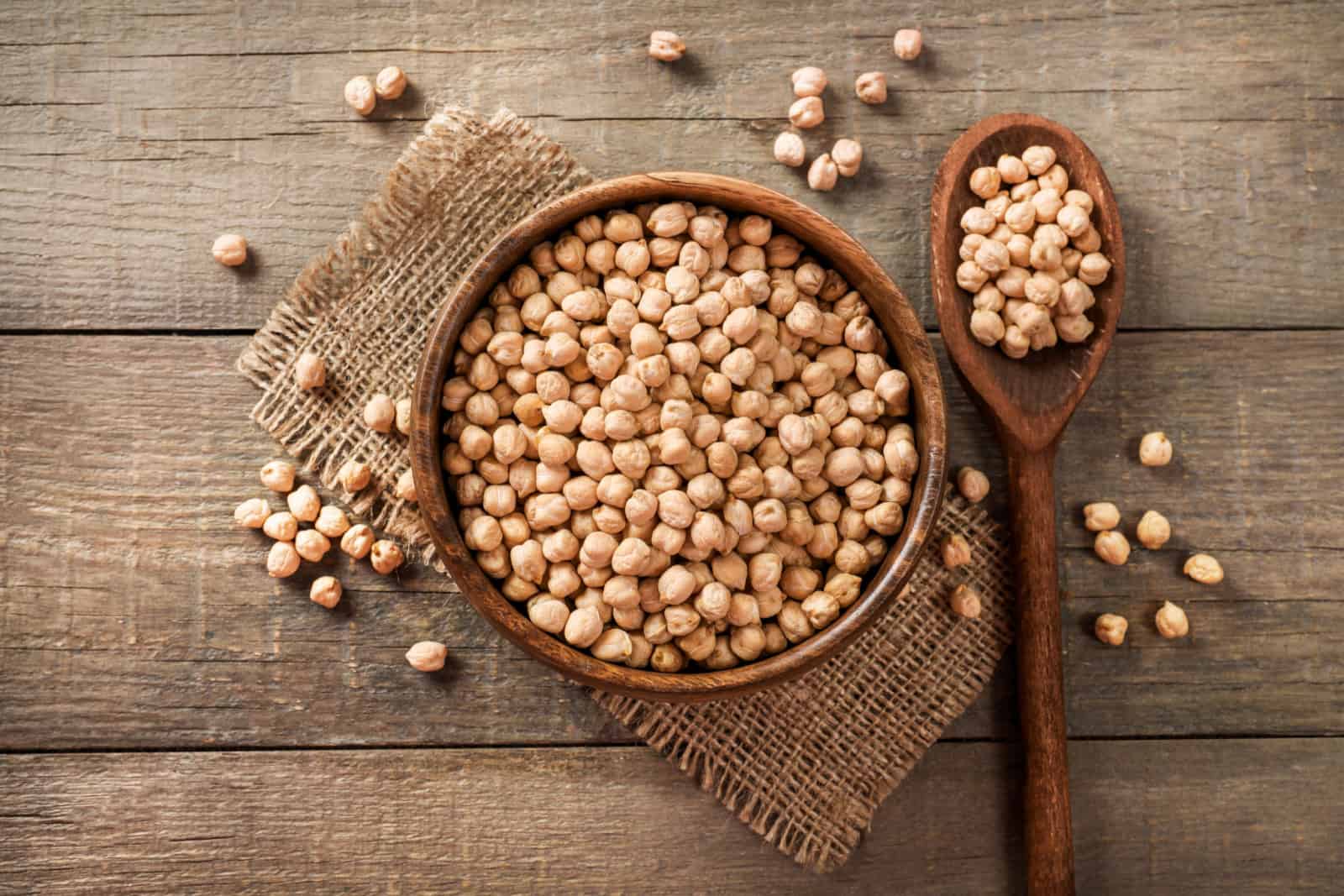 Wooden bowl and wooden spoon full of chickpeas