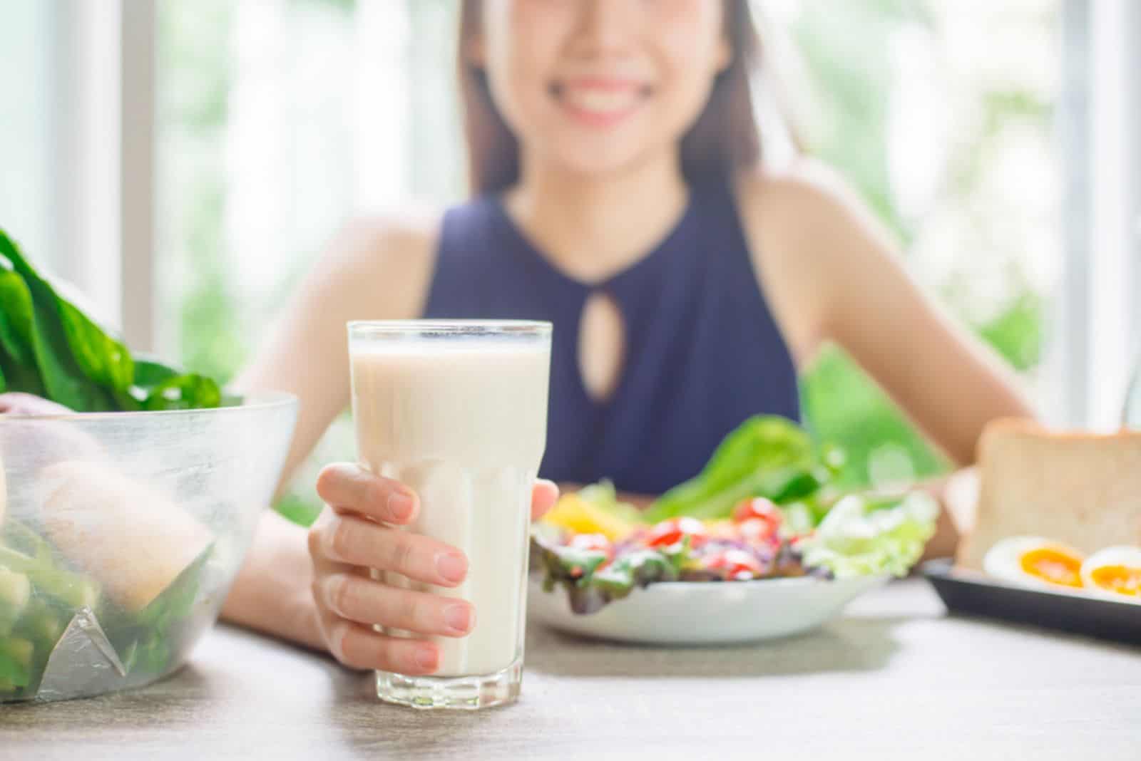 Young asian woman attractive woman with milk and healthy breakfast in kitchen
