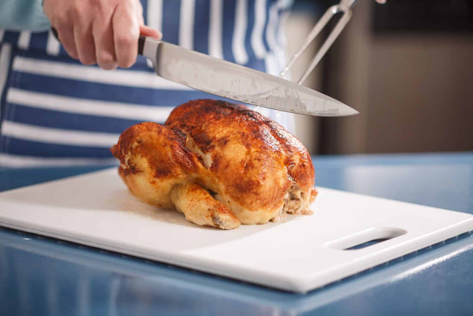a woman cuts a Rotisserie Chicken