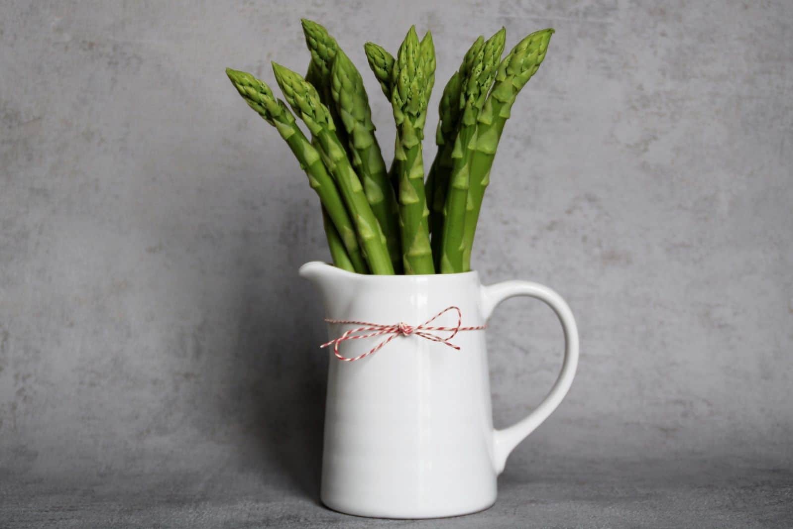 asparagus in a ceramic pitcher