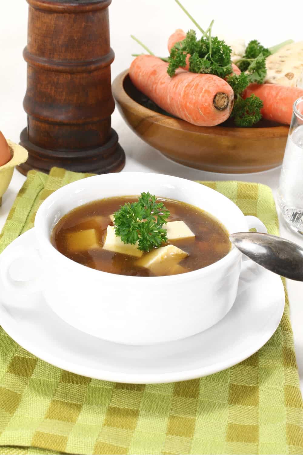 Consommé di manzo con verdure sullo sfondo