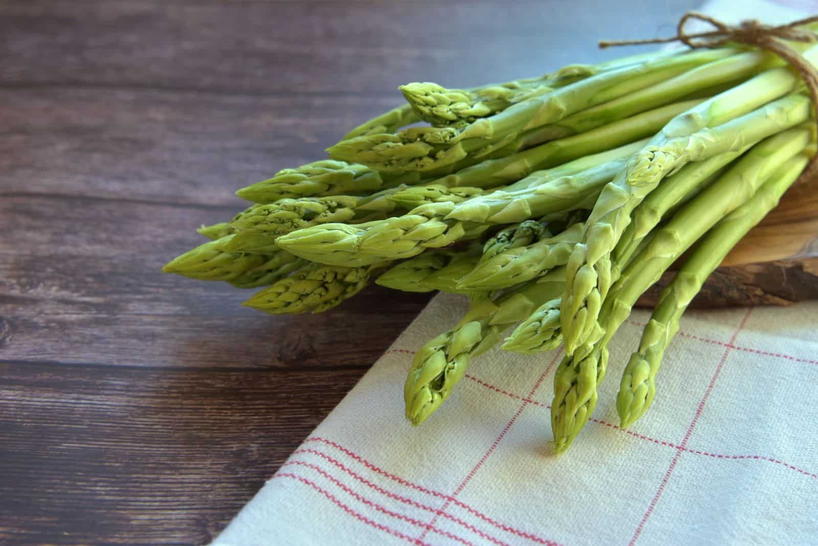 fresh asparagus on wooden desk